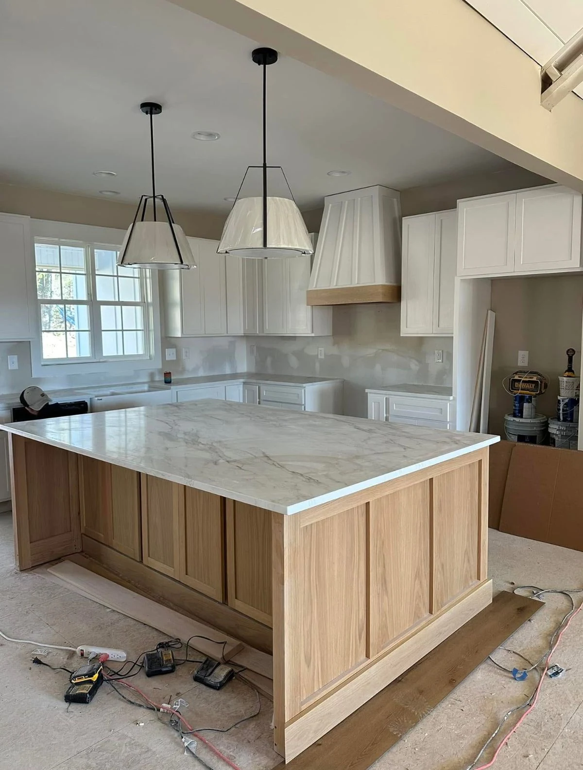 Open kitchen with wood island, white cabinetry and breakfast seating