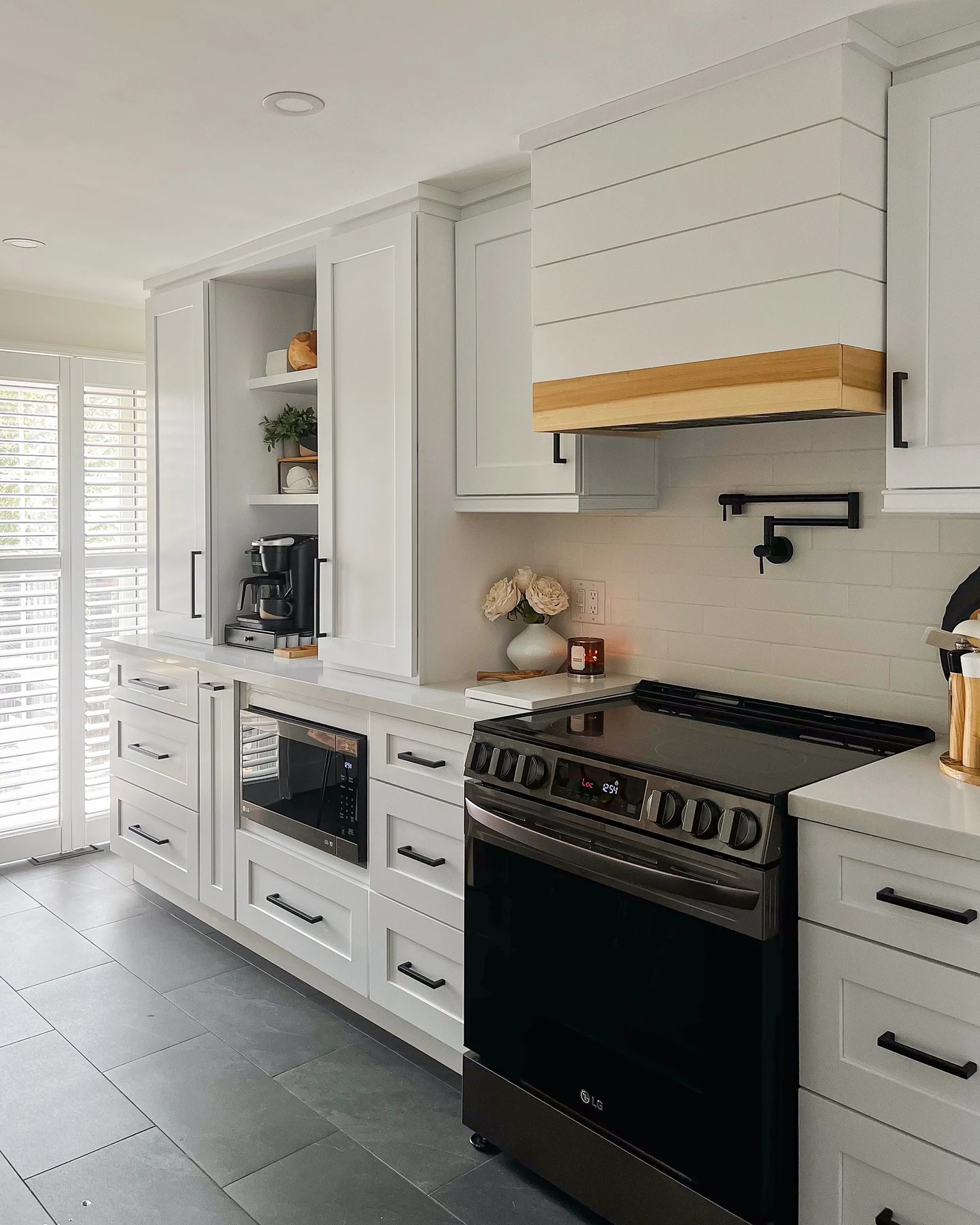White kitchen with dark lower cabinets and stainless steel range