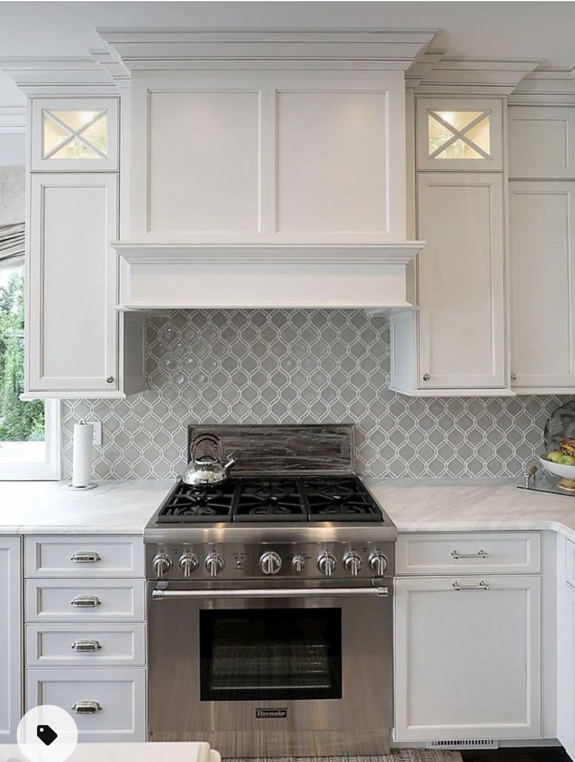 Traditional white kitchen with decorative range hood and cabinetry