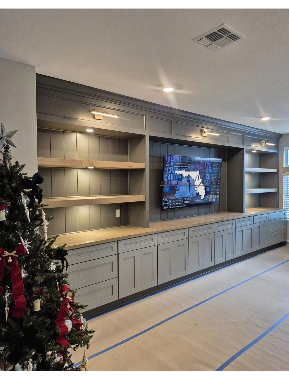 Built-in living room wall cabinets with open shelves and television