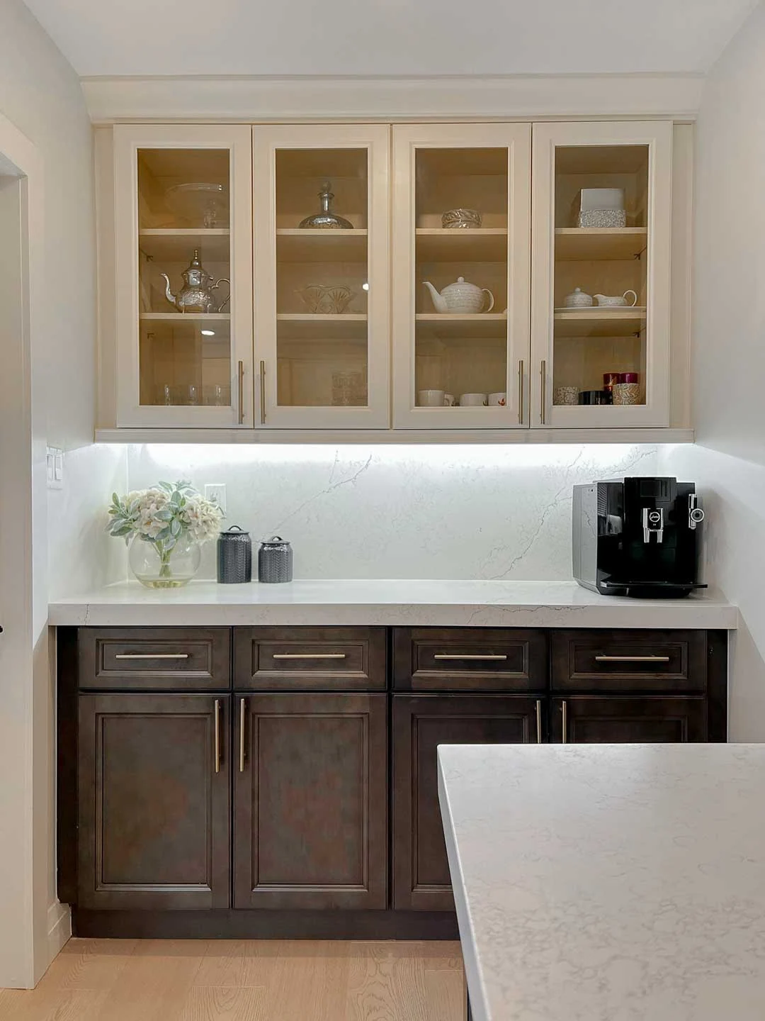 Compact home bar with glass-front shelving and wood base cabinets